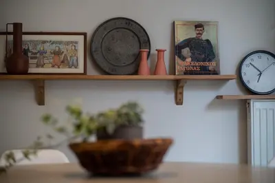 a shelf with a clock and vases on a wall at 1BR Athenian Serenity 15 Minutes From Acropolis in Athens