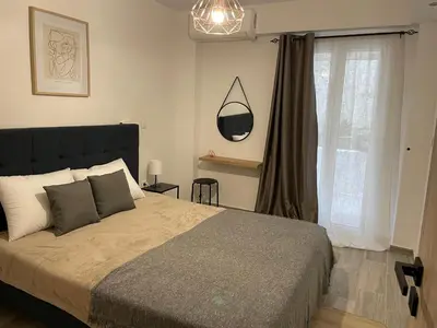 a bedroom with a large bed and a window at Pagrati Green Studio in Athens