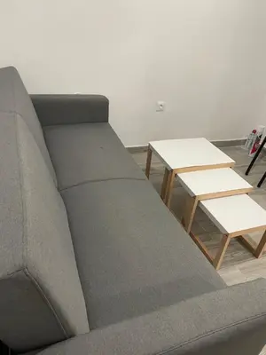 a couch and two tables in a room at Pagrati Green Studio in Athens