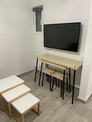 a room with a table and a tv on a wall at Pagrati Green Studio in Athens
