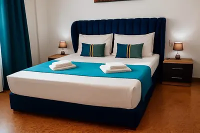 a large bed with blue and white sheets and pillows at Technopolis Luxury Apartments in Athens