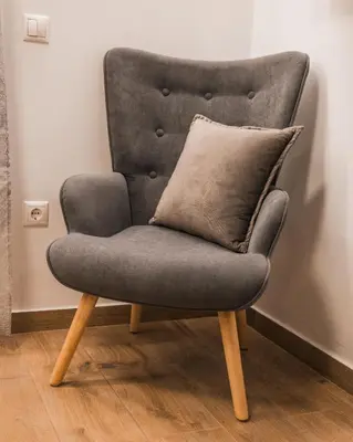 a grey chair with a pillow on top of it at Technopolis Luxury Apartments in Athens