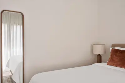 a bedroom with a white bed and a mirror at Sunny and Comfy Apartment in kolonaki in Athens