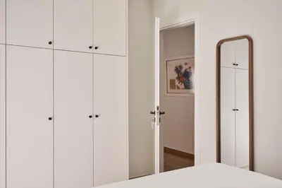 a bedroom with white cabinets and a mirror at Sunny and Comfy Apartment in kolonaki in Athens