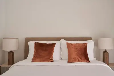 a bed with white sheets and pillows and two lamps at Sunny and Comfy Apartment in kolonaki in Athens