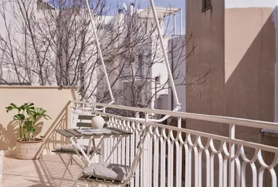 a balcony with a table and chairs on a building at Sunny and Comfy Apartment in kolonaki in Athens