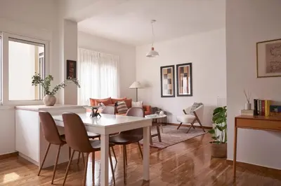 a dining room and living room with a table and chairs at Sunny and Comfy Apartment in kolonaki in Athens