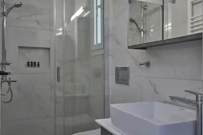 a white bathroom with a shower and a sink at Bright Apt-Archeological Museum in Athens