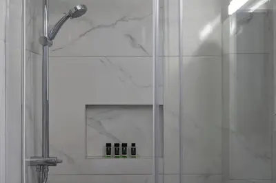 a shower with a glass door in a bathroom at Bright Apt-Archeological Museum in Athens