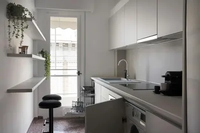 a kitchen with white cabinets and a sink and a stool at Bright Apt-Archeological Museum in Athens