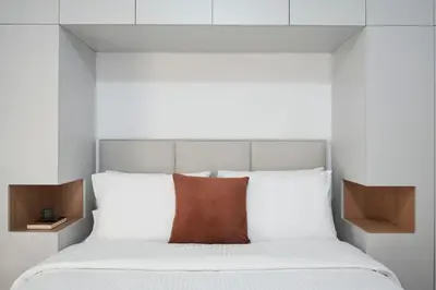 a bed with white sheets and a red pillow at Bright Apt-Archeological Museum in Athens