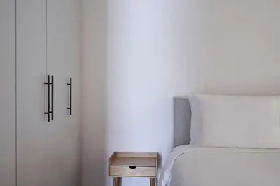 a bedroom with a bed and a nightstand next to a table at Bright Apt-Archeological Museum in Athens