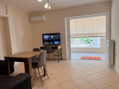 a living room with a dining room table and a window at 2BR Apartment next to National Archaeological Museum and AUEB in Athens