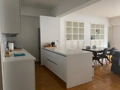 a kitchen with white cabinets and a table with chairs at Apartment in Fancy Athenian Neighbourhood in Athens