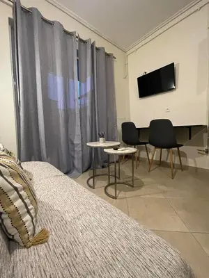a bedroom with a bed and a flat screen tv at Cozy Apartment In The Heart Of Athens in Athens