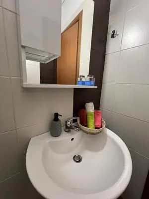 a bathroom sink with a mirror and a basket of towels at Cozy Apartment In The Heart Of Athens in Athens
