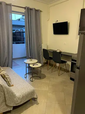a living room with a table and a tv at Cozy Apartment In The Heart Of Athens in Athens