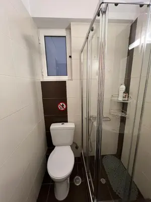 a bathroom with a toilet and a glass shower at Cozy Apartment In The Heart Of Athens in Athens