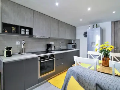 a kitchen with grey cabinets and a table and chairs at Dimosthenis_loft2 in Athens