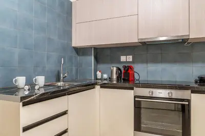 a kitchen with white cabinets and a sink and a stove at Elvita Apartments 4 in Athens
