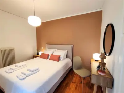 a bedroom with a large white bed and a mirror at Vouliagmeni Iasonos Residence Central Stylish Flat in Athens