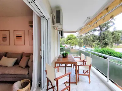 a balcony with a table and chairs and a couch at Vouliagmeni Iasonos Residence Central Stylish Flat in Athens