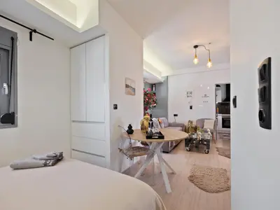 a bedroom with a bed and a table and a living room at Athens luxurious loft in Athens