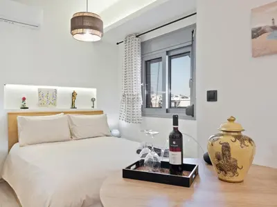 a bedroom with a bed and a table with a bottle of wine at Athens luxurious loft in Athens