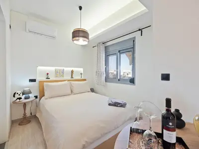 a white bedroom with a bed and a window at Athens luxurious loft in Athens