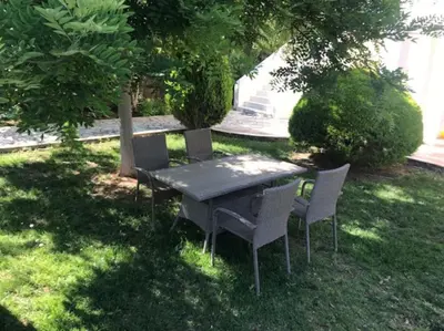 a picnic table and chairs sitting in the grass at Grand Villa Lagonisi in Kalívia Thorikoú