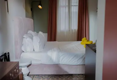 a hotel room with a white bed and a chair at Bugan-Villa in Athens
