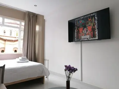 a bedroom with a bed and a tv on the wall at Syntagma Nest Apartment in Athens