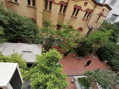 a black cat sitting on the side of a building at Syntagma Nest Apartment in Athens