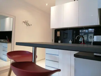 a kitchen with a counter and a red chair at Syntagma Nest Apartment in Athens