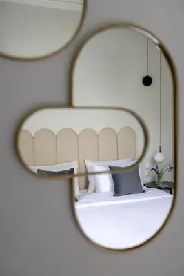 a mirror reflecting a bedroom with a bed with pillows at Acropolis Villa 3BR 9ppl 10 minutes Metro&Museum in Athens