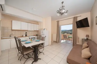 a kitchen and living room with a table and a couch at Villa Clotho in Porto Rafti