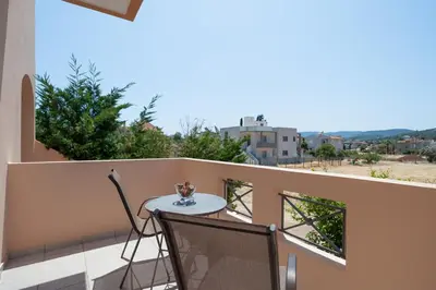 a table and chairs on a balcony with a view at Villa Clotho in Porto Rafti