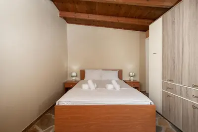 a bedroom with a bed with two white pillows at Villa Clotho in Porto Rafti