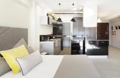 a bedroom with a white bed and a kitchen at Stylish Boutique Loft With Private Balcony in Athens