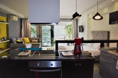 a kitchen and a living room with a couch at Stylish Boutique Loft With Private Balcony in Athens