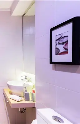 a bathroom with a sink and a toilet and a picture at Stylish Boutique Loft With Private Balcony in Athens