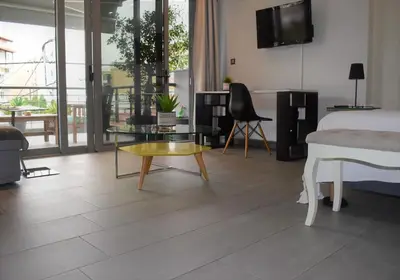 a bedroom with a bed and a table and a tv at Stylish Boutique Loft With Private Balcony in Athens