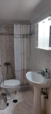 a bathroom with a white sink and a toilet at Denis house in Artemida