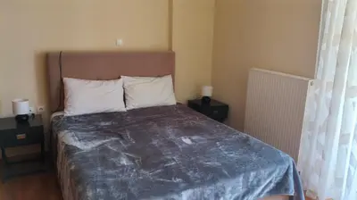 a bed in a bedroom with two night stands and two lamps at Denis house in Artemida