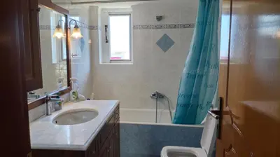 a bathroom with a sink and a shower curtain at Denis house in Artemida