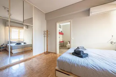 a bedroom with a large bed and a mirror at Glyfada Central Walk to Shops, Near Beach in Athens