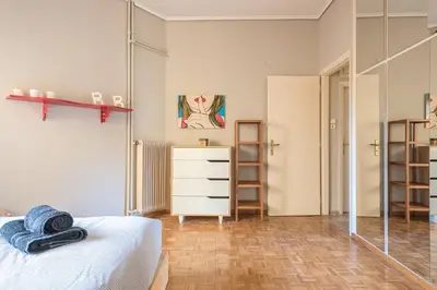 a bedroom with a bed and a dresser and a mirror at Glyfada Central Walk to Shops, Near Beach in Athens