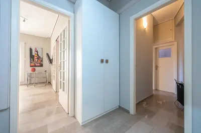 a hallway with white walls and tile floors at Glyfada Central Walk to Shops, Near Beach in Athens
