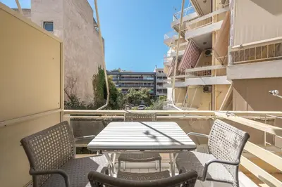 a patio with a table and chairs on a balcony at Glyfada Central Walk to Shops, Near Beach in Athens