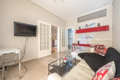 a living room with a couch and a flat screen tv at Glyfada Central Walk to Shops, Near Beach in Athens